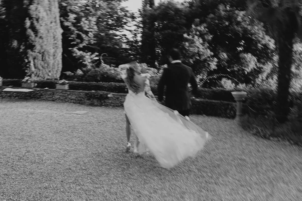Brautpaar in Bewegung im Garten einer italienischen Villa Verschwommene Szene eines Brautpaars, das gemeinsam durch den Garten einer historischen Hochzeitslocation läuft – authentische Momentaufnahme