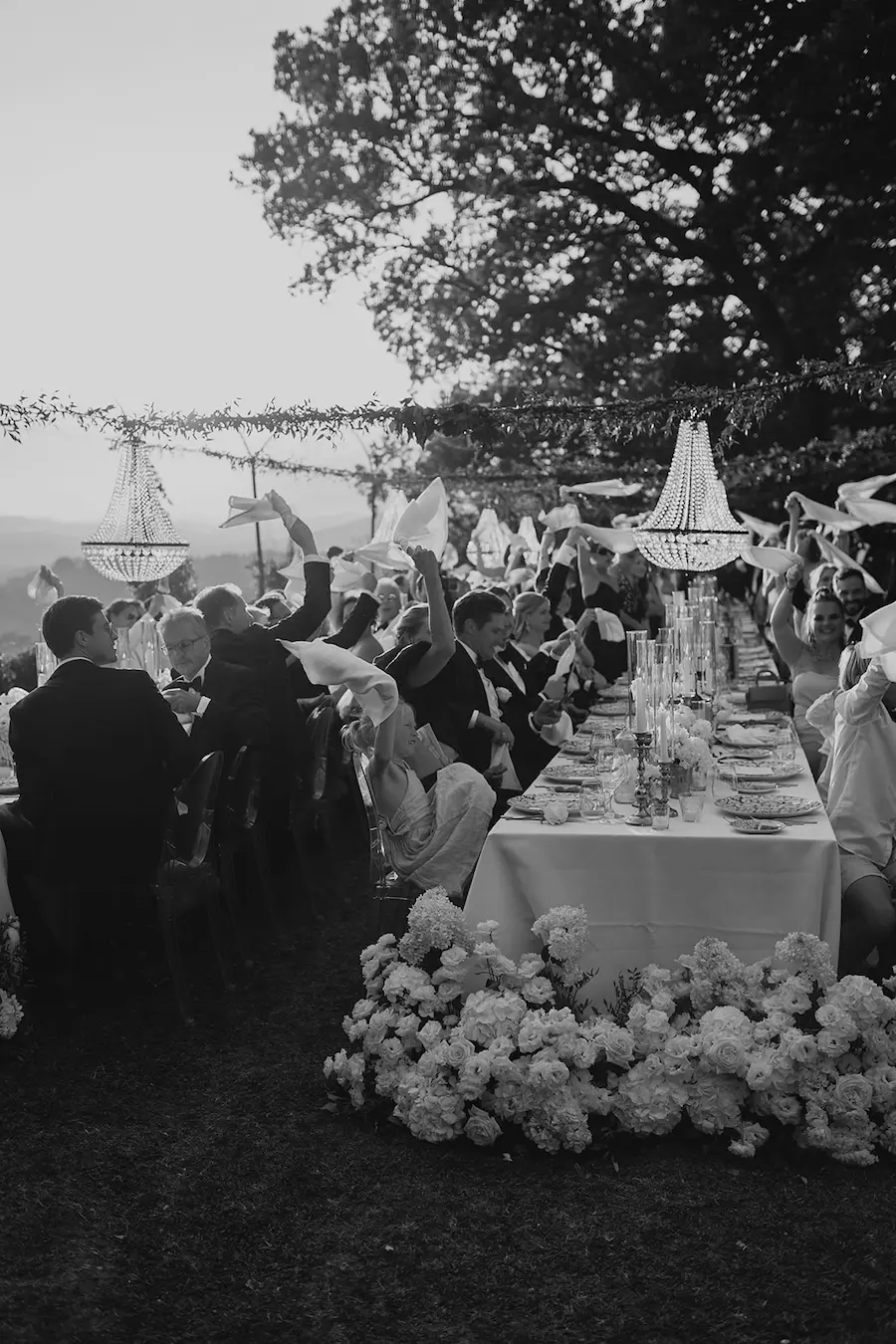 Emotionale Hochzeitsmomente festhalten – echte Stimmung zeigen Hochzeitsgäste feiern ausgelassen an einer langen Tafel – perfekte Szene für authentisches Storytelling auf Instagram