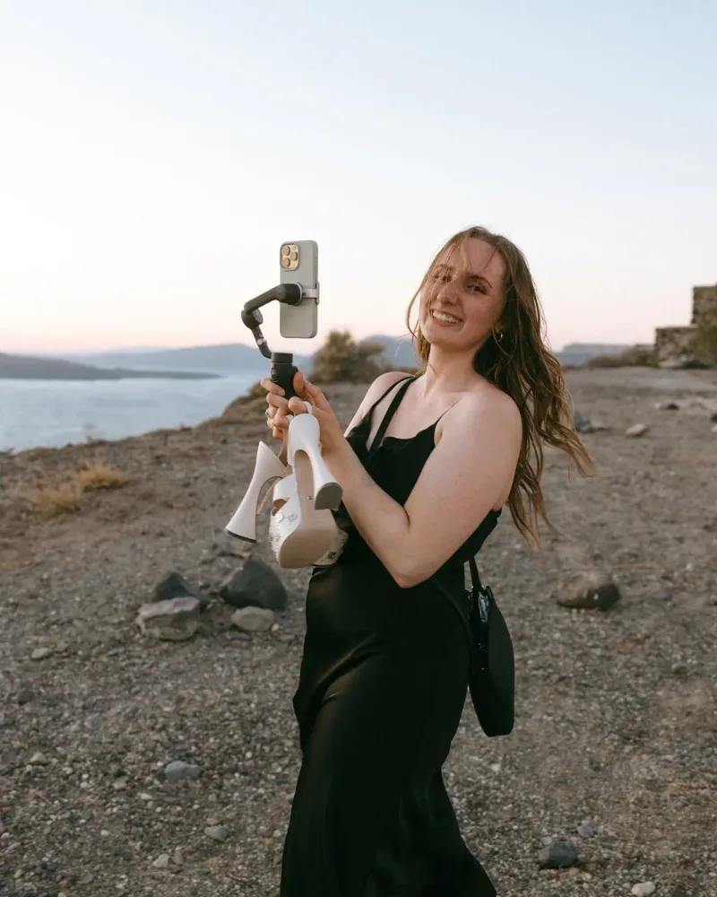 Theresa Sander, Wedding Content Creator von Dreamers Content, filmt mit Smartphone und Gimbal auf Santorini